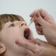 Criança recebendo vacina de gotinha