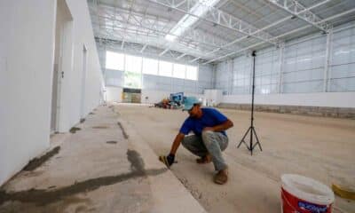 Trabalhador finaliza detalhes no Centro de Excelência do Basquete Ovídeo Bueno, em Jundiaí, com estruturas modernas e espaço amplo.