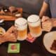Duas pessoas brindam com duas canecas de chope no restaurante Outback