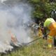 Homens de órgãos municipais combatendo incêndio em área de mata em Jundiaí.