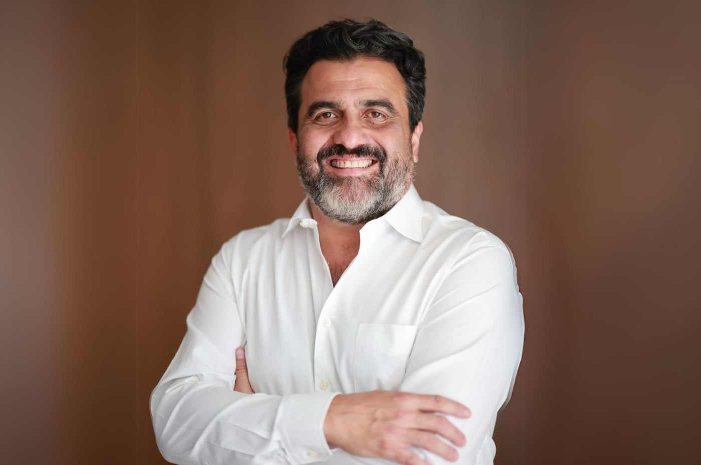 Homem de barba e cabelos escuros, usando camisa branca, sorri com os braços cruzados. Ricardo Bocalon, pré-candidato a prefeito de Jundiaí.