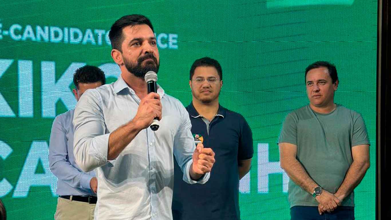 Henrique Martin discursando na convenção do MDB como candidato a prefeito de Cabreúva, com apoiadores ao fundo e uma criança à frente.