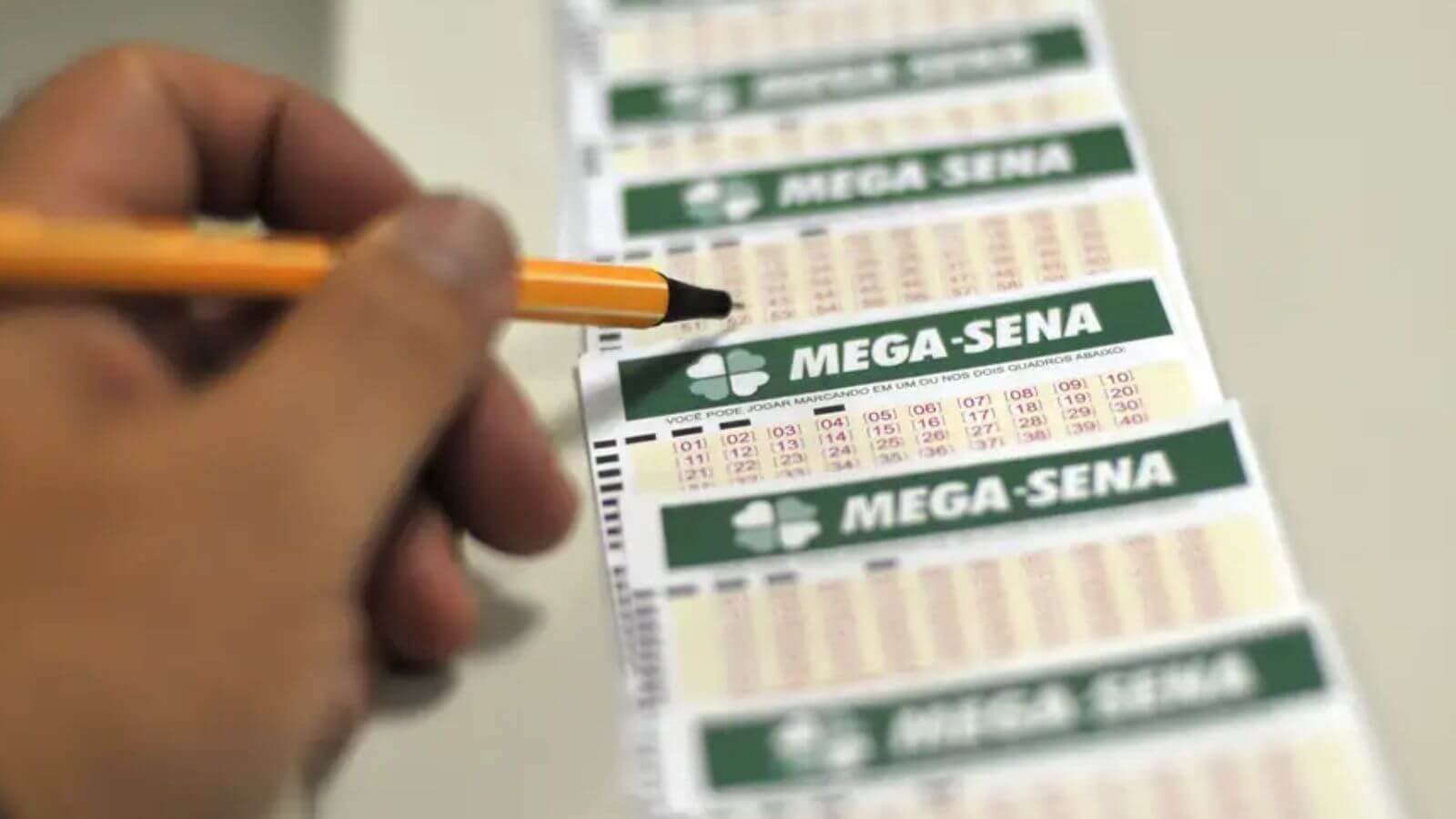 Pessoa com bilhetes da Mega-Sena