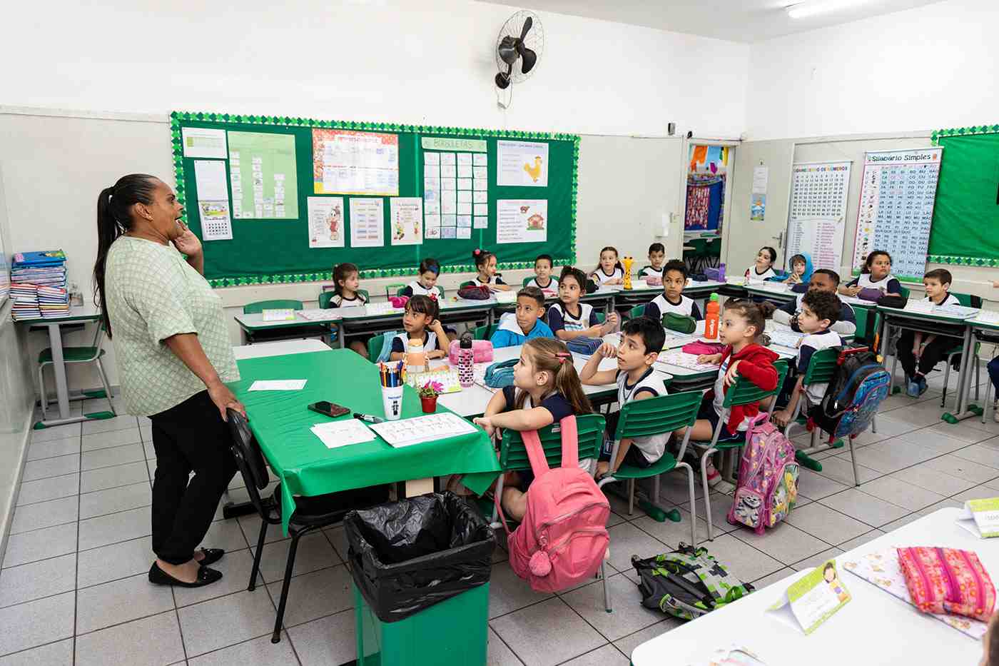 Professora ensinando alfabetização em Jundiaí para alunos do 1º ano na EMEB Armanda Santina Polenti, sala de aula cheia e atenta.
