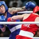 Beatriz Ferreira (de azul) em ação durante luta de boxe nos Jogos Olímpicos Paris 2024 contra Kellie Harrington (de vermelho)