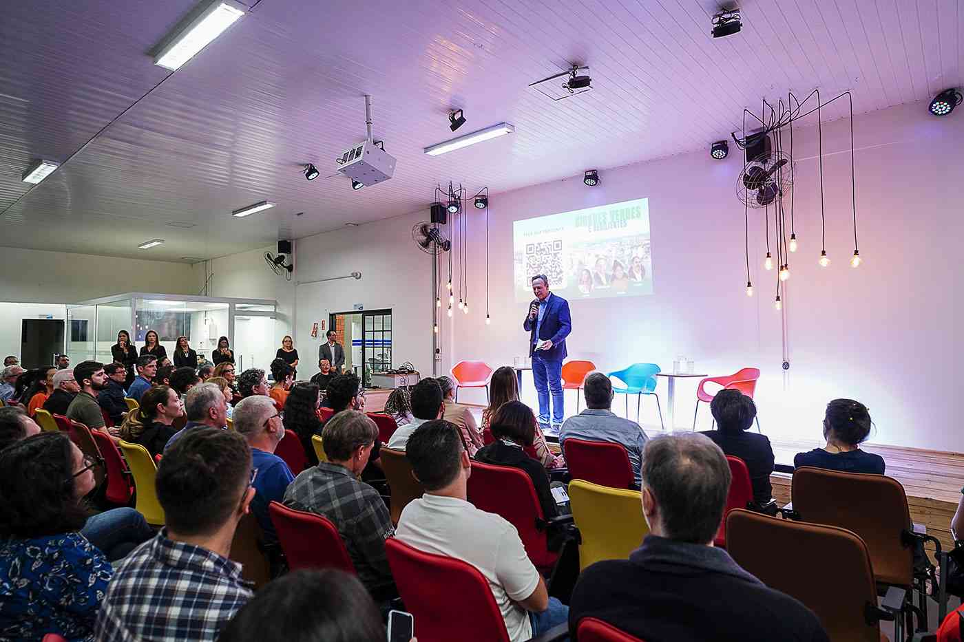 José Antonio Parimoschi discursando em evento sobre cidades verdes e resilientes em Jundiaí, com audiência atenta e diversificada.