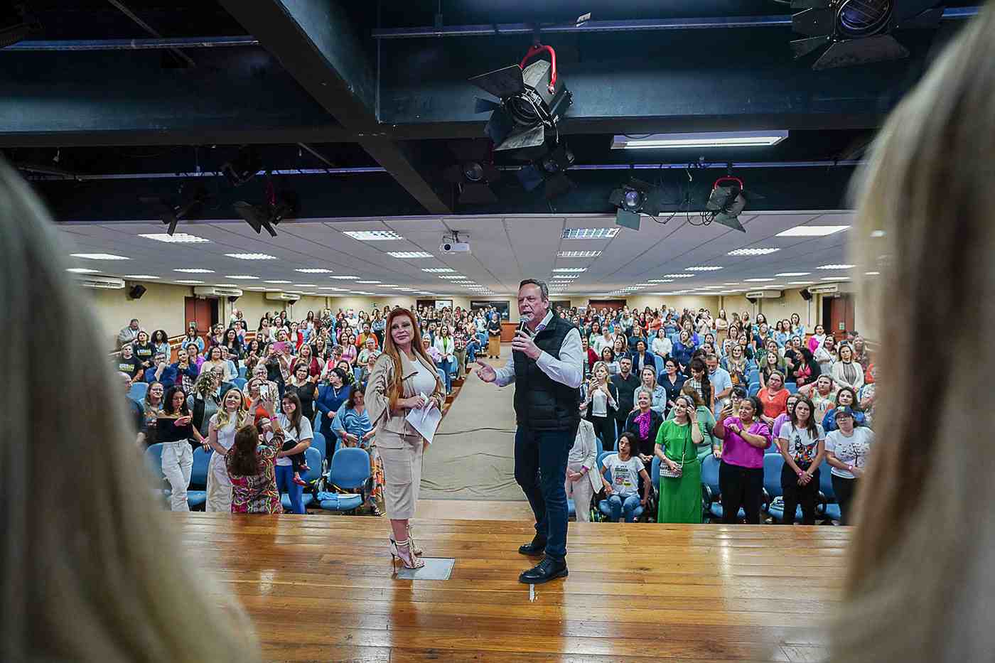 José Antonio Parimoschi e Katia Parimoschi falando para um auditório lotado durante o encontro do Comitê de Mulheres na UNIP.