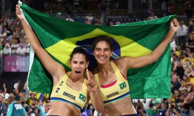 Duda e Ana Patrícia celebram a vitória com a bandeira do Brasil após conquistarem o ouro no vôlei de praia em Paris 2024.