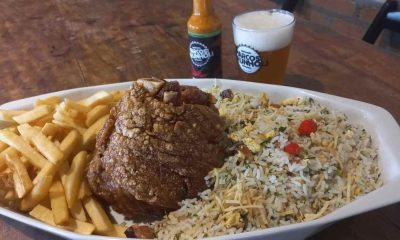 Joelho de porco crocante com arroz biro-biro e batatas fritas servido na Cervejaria Marcos Brunholi, acompanhado de cerveja artesanal.