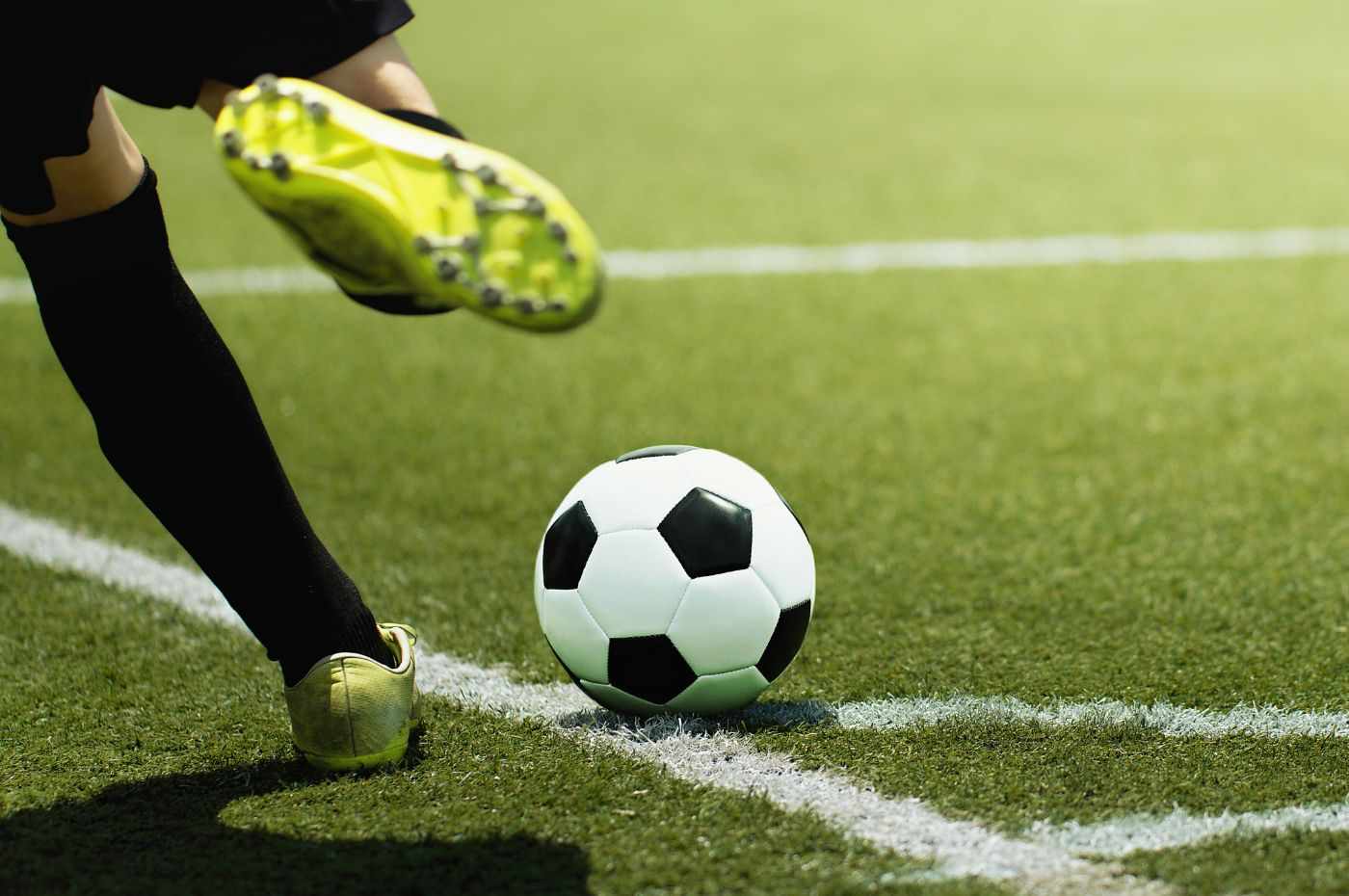 Jogador de futebol prestes a chutar a bola em um campo de grama durante jogo da Copa do Brasil.