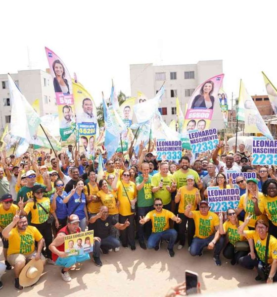 Grupo de apoiadores de Parimoschi em caminhada de campanha no Jardim Novo Horizonte, segurando bandeiras e cartazes de candidatos aliados.