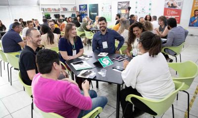 Empresários participando de uma Rodada de Negócios da ACE Jundiaí, em um ambiente de networking com várias mesas e interações.