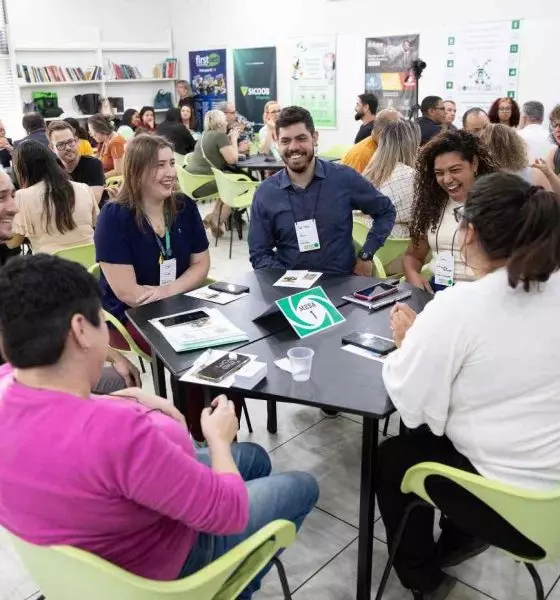 Empresários participando de uma Rodada de Negócios da ACE Jundiaí, em um ambiente de networking com várias mesas e interações.