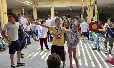 APAE Jundiaí realiza baile da primavera para alunos; jovens se divertem com professores em meio às flores.