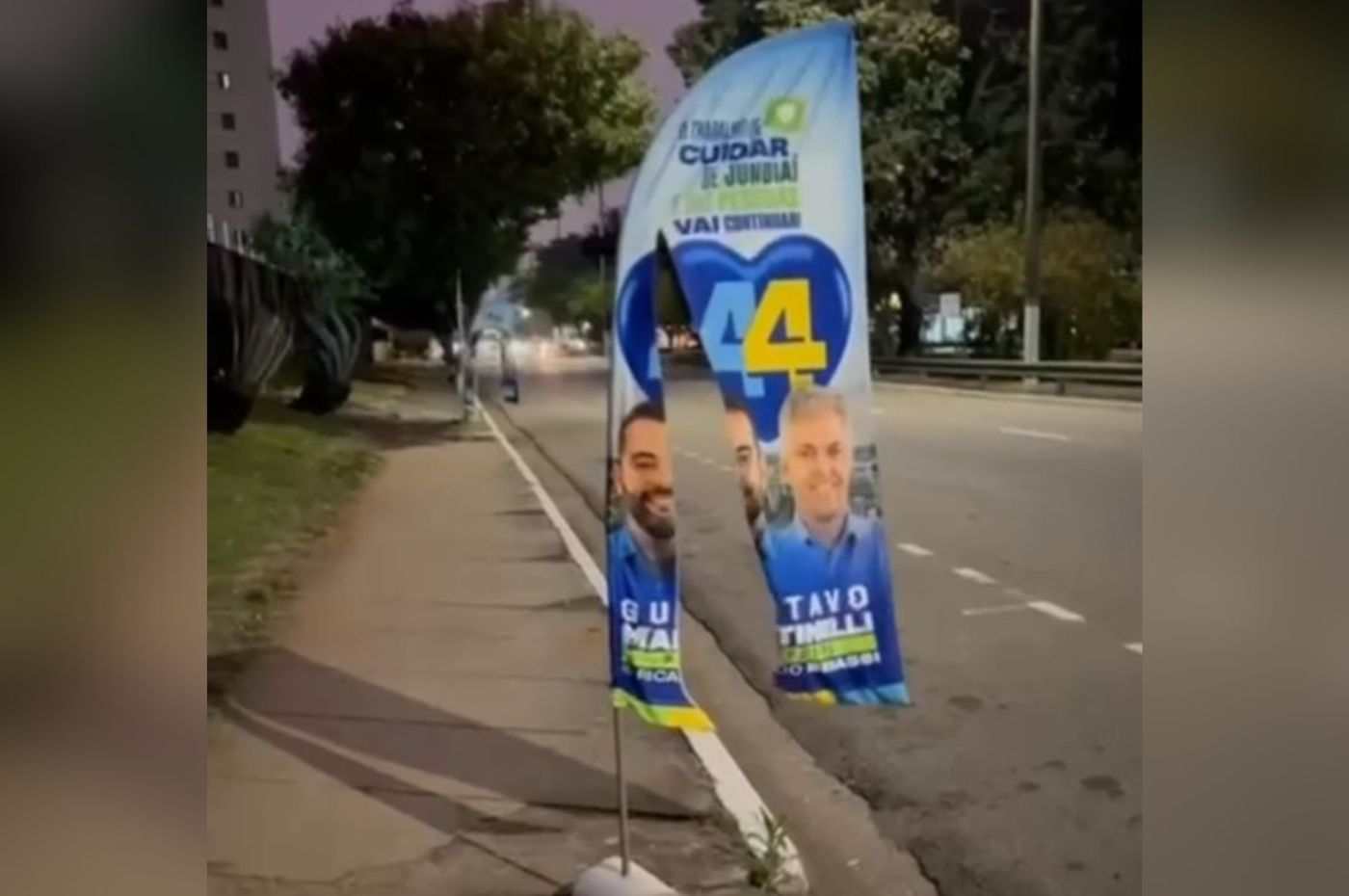 Banner eleitoral de Gustavo Martinelli e Ricardo Benassi vandalizado em calçada de Jundiaí durante campanha de 2024.