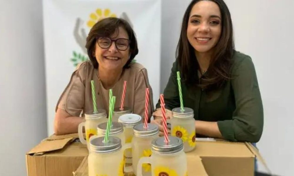 Mulheres posam com as canecas girassol na APAE Jundiaí.