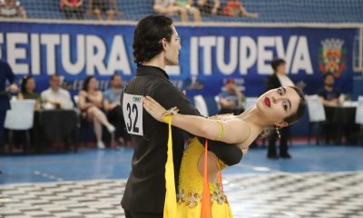 Casal se apresentando em competição de dança esportiva em ginásio de Itupeva.