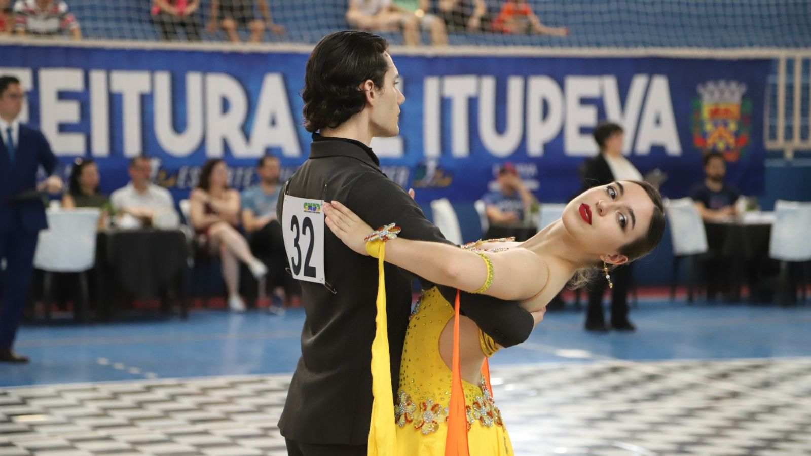 Casal se apresentando em competição de dança esportiva em ginásio de Itupeva.