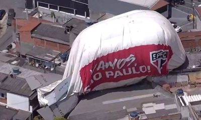 Dirigível cai em telhado de residências. Imagem mostra equipamento sobre telhado e com dizeres do time do São Paulo.