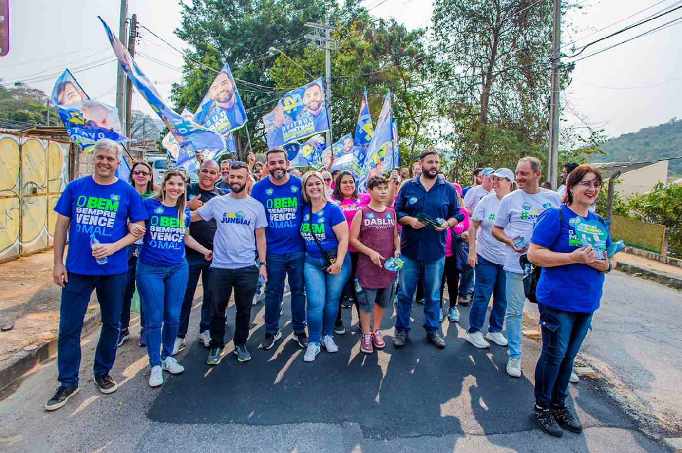 Gustavo Martinelli e grupo de apoiadores em passeata na região sul de Jundiaí, segurando bandeiras de campanha e interagindo com moradores.