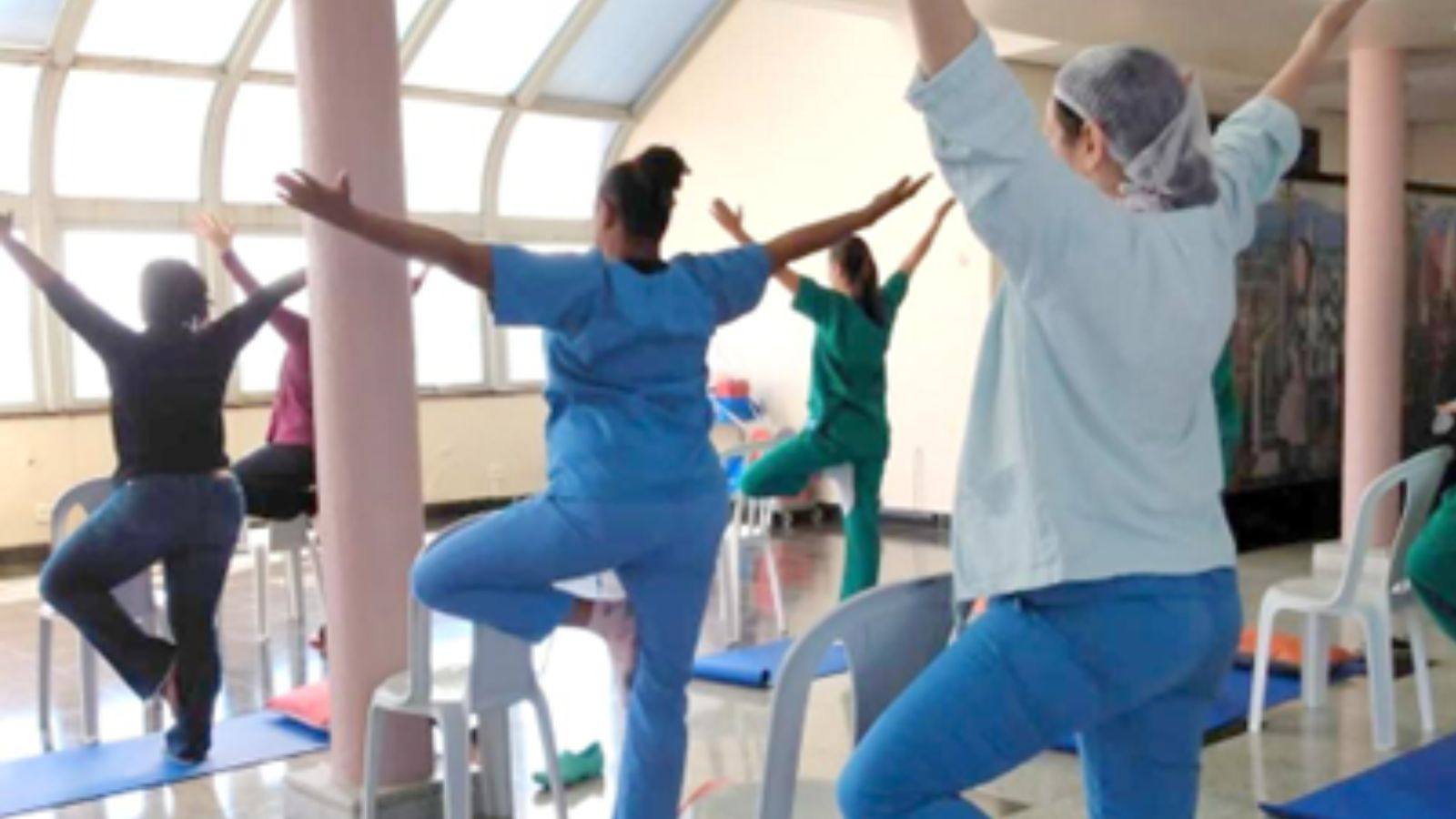 Colaboradores da área de saúde praticam yoga no Hospital São Vicente em conjunto.