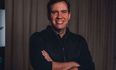 João Branco no Café Show da ACE Jundiaí, palestrante reconhecido, sorrindo e posando de braços cruzados em ambiente formal.