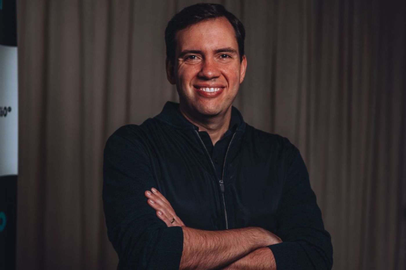 João Branco no Café Show da ACE Jundiaí, palestrante reconhecido, sorrindo e posando de braços cruzados em ambiente formal.