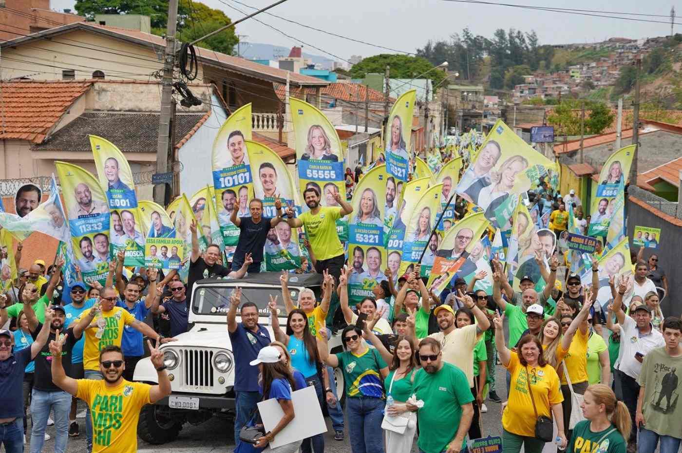 Multidão em caminhada política com cartazes de José Antônio Parimoschi e diversos candidatos pelas ruas de Jundiaí durante campanha eleitoral.