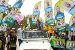 Parimoschi, Luiz Fernando e apoiadores participam de evento eleitoral no Jardim Tamoio, Jundiaí, com bandeiras e cartazes de campanha.