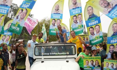 Parimoschi, Luiz Fernando e apoiadores participam de evento eleitoral no Jardim Tamoio, Jundiaí, com bandeiras e cartazes de campanha.