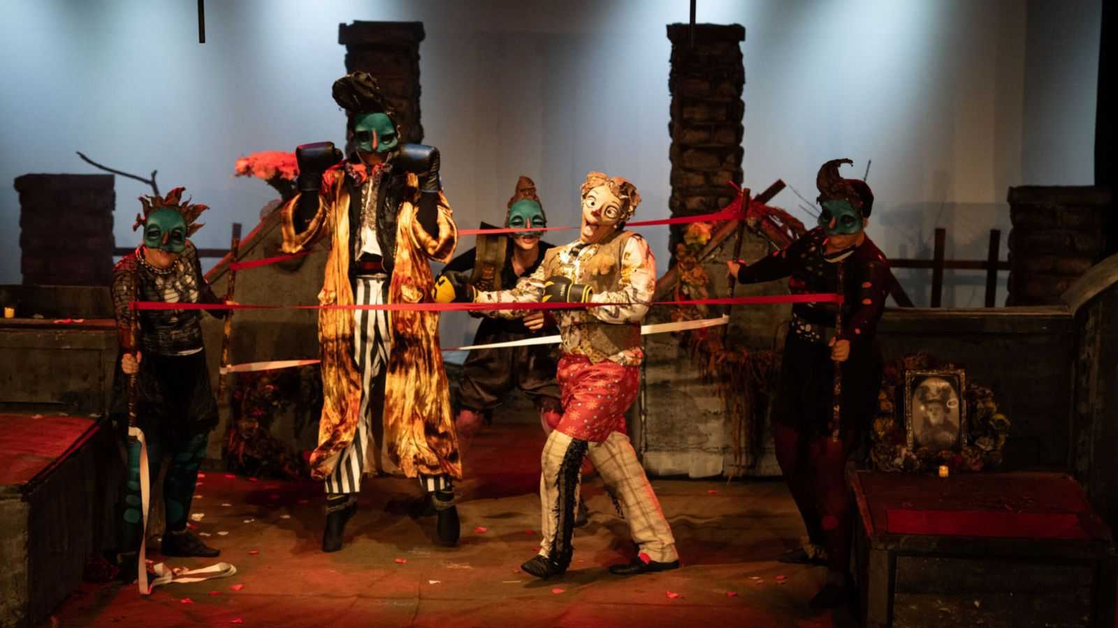 Peça de teatro de Jundiaí com personagens lutadores e palhaços em apresentação.