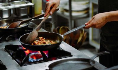 Vagas de emprego para trabalhar em cozinhas estão abertas e, na imagem, mostra uma pessoa cozinhando, ilustrando atividade do cargo.