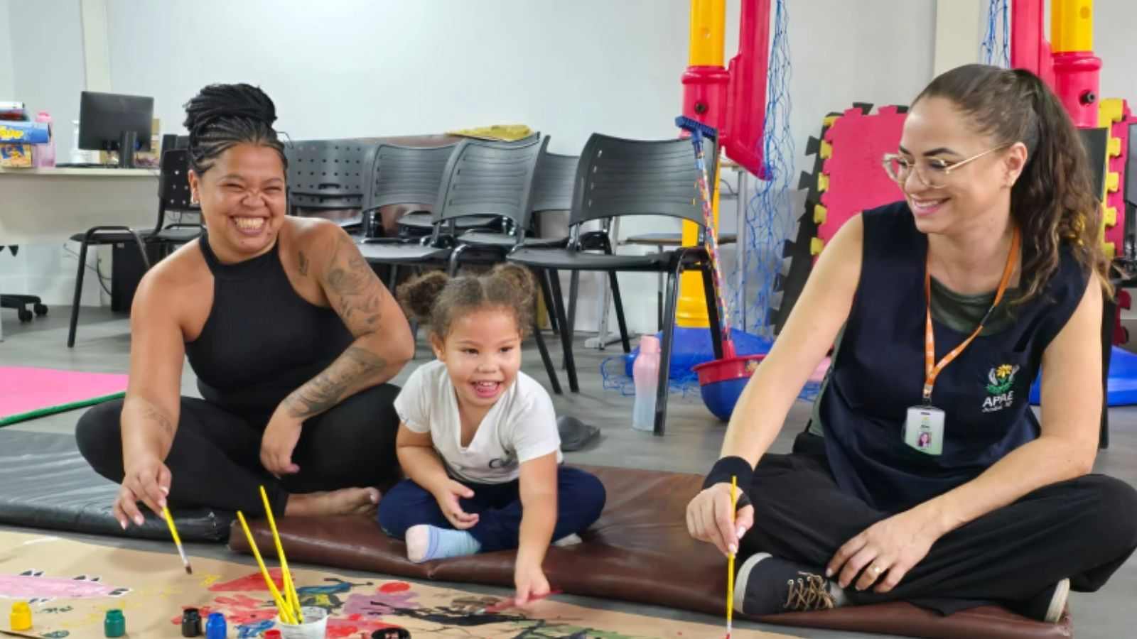 Mãe e filha, junto de terapeuta, em atividade da APAE Jundiaí.