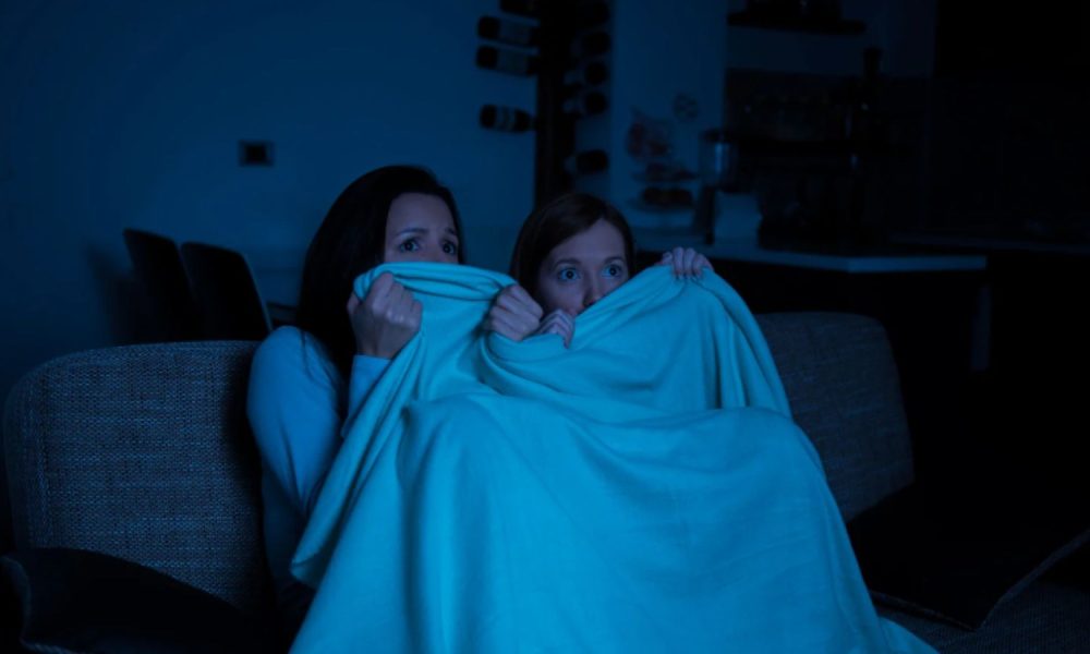 Mulheres assistindo filme de terror durante halloween.