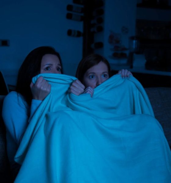 Mulheres assistindo filme de terror durante halloween.