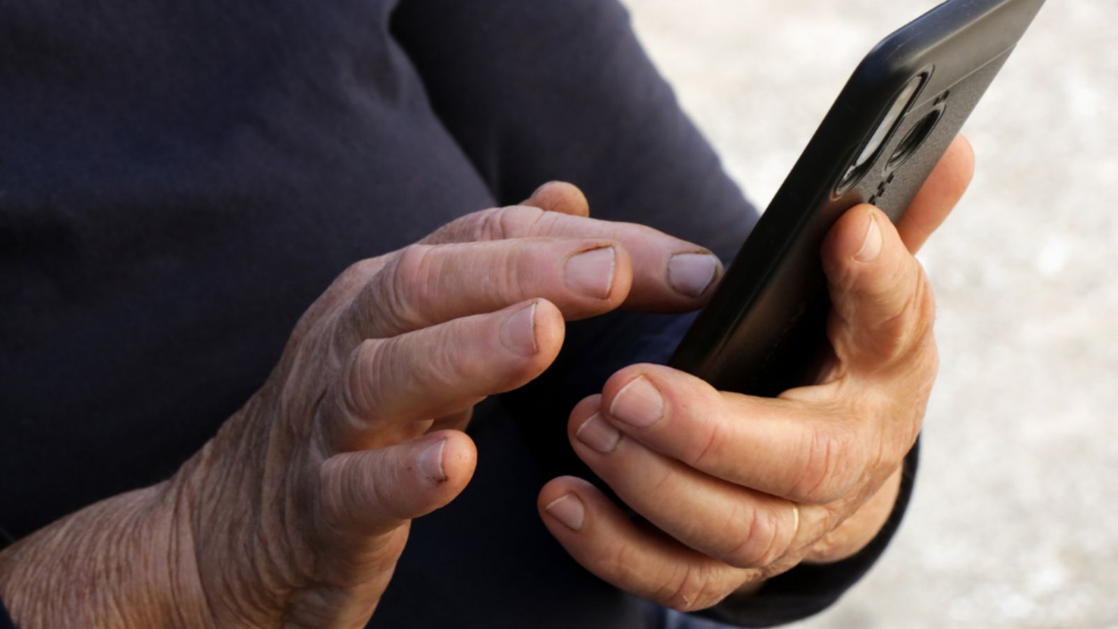 Idoso mexendo em celular fazendo alusão aos golpes aplicados em aposentados de Jundiaí.