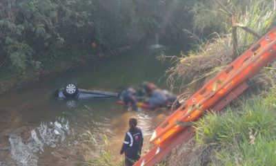 Carro dentro das águas do Rio Jundiaí e equipe de resgate com a vítima.