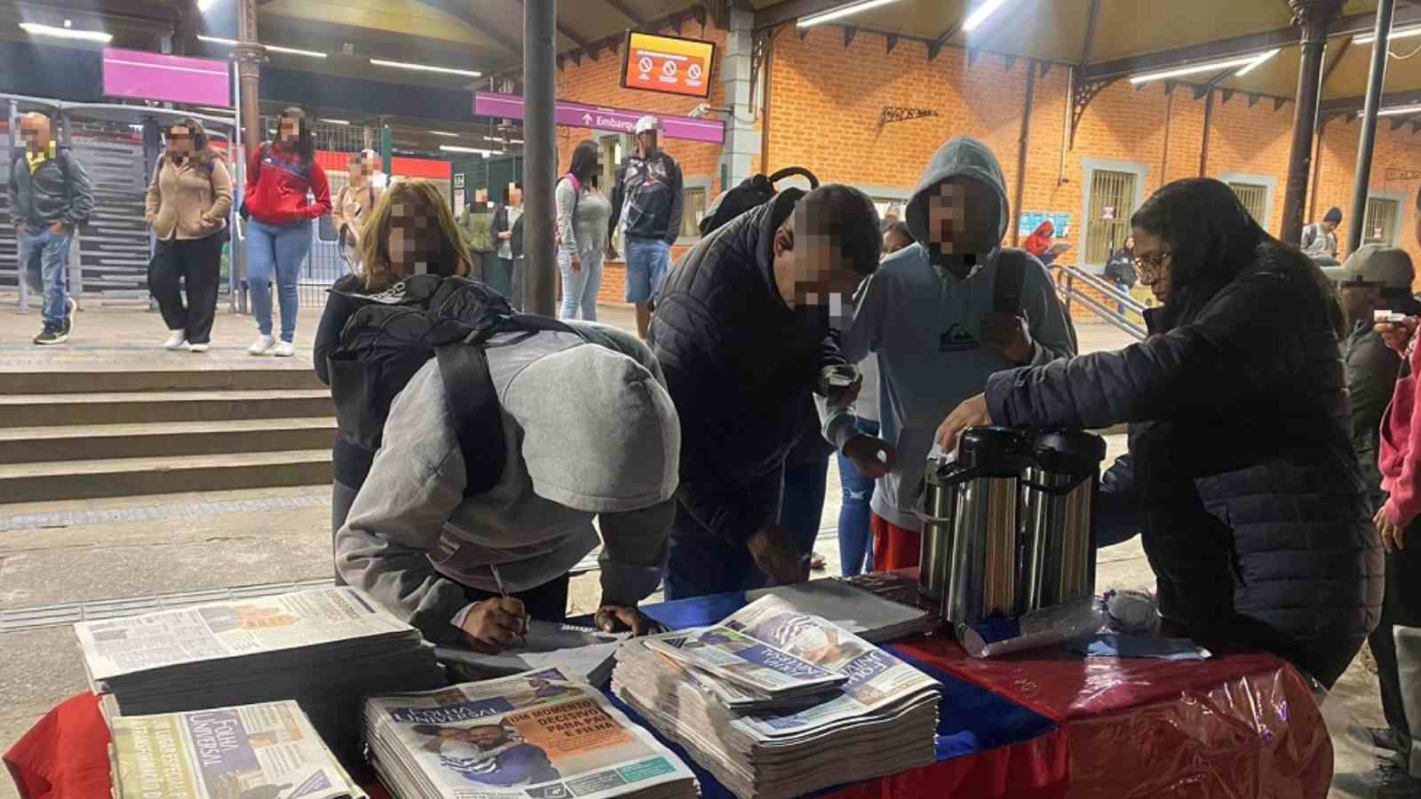 Voluntários da Universal entregando café em frente de estação de trem de Jundiaí.