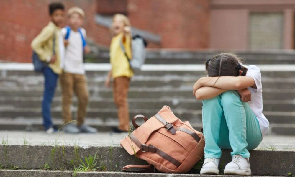 Menina sofrendo bullying de três garotos em escola.