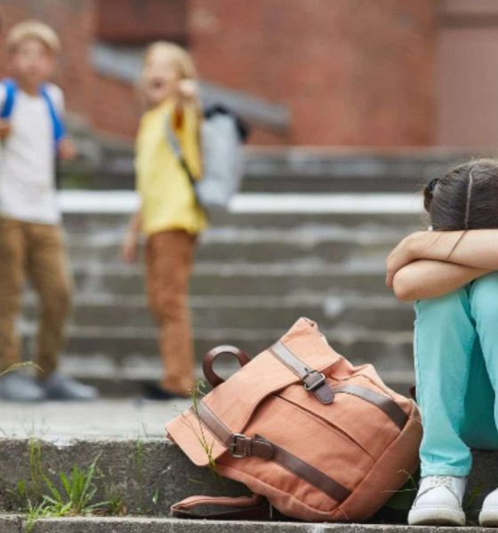 Menina sofrendo bullying de três garotos em escola.