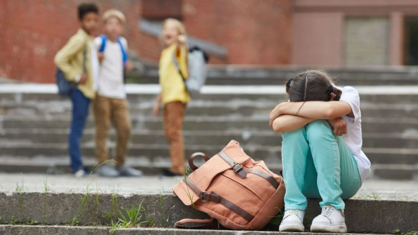 Menina sofrendo bullying de três garotos em escola.