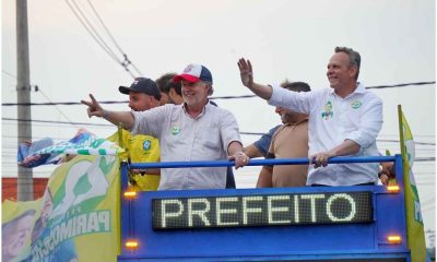 José Antônio Parimoschi e apoiadores acenam em carreata da vitória em Jundiaí, destacando campanha para prefeito, com bandeiras e placas.