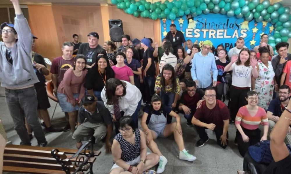 Alunos da APAE Jundiaí em frente ao palco posando para fotos.