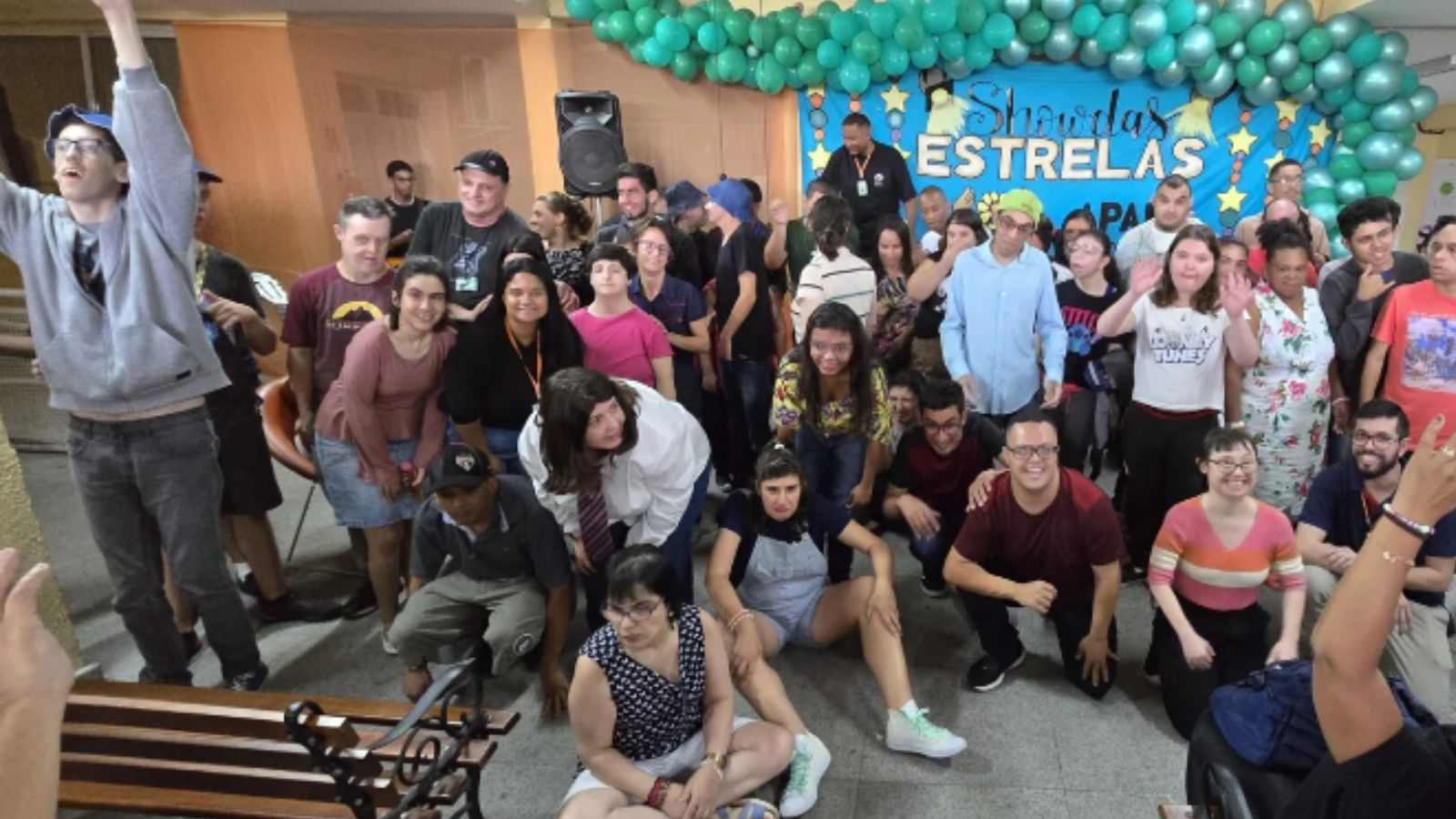 Alunos da APAE Jundiaí em frente ao palco posando para fotos.