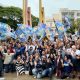 Grupo de apoiadores com bandeiras de Gustavo Martinelli em caminhada no centro de Jundiaí, levantando mãos com o número 44