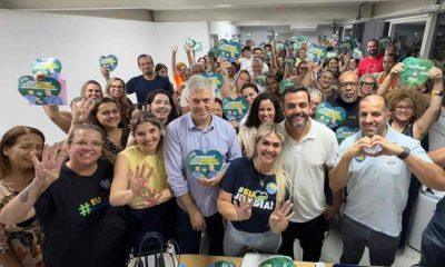 Grupo de pessoas sorrindo, segurando cartazes de campanha 'Jundiaí merece o dobro' com Gustavo Martinelli e outros candidatos em evento político.