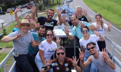 Gustavo Martinelli e Ricardo Benassi, acompanhados de apoiadores, posam em carreata em Jundiaí, fazendo o número "4" com as mãos.